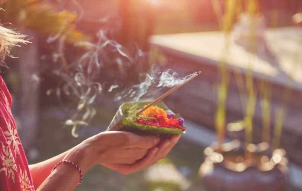 Incense to the gods Incense and flowers are being offered to the gods.