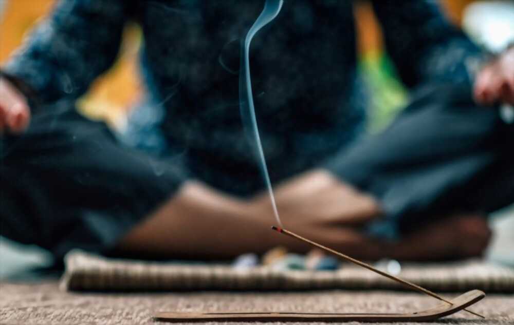 man meditating with incense A man is meditating with incense.